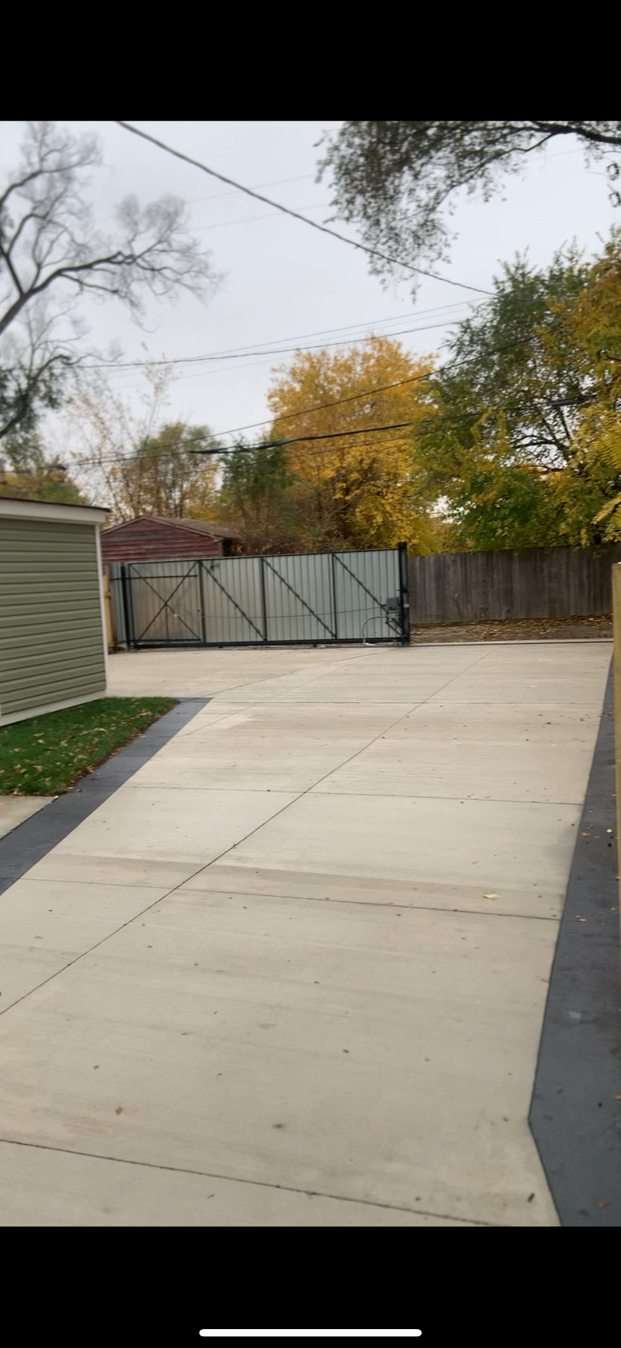 Completed residential concrete driveway with gate at the back